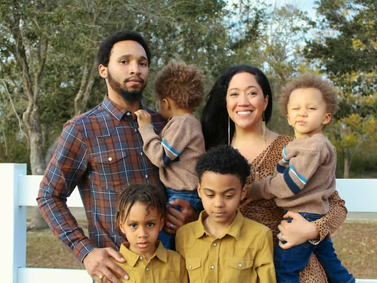 Family with young children standing outside together