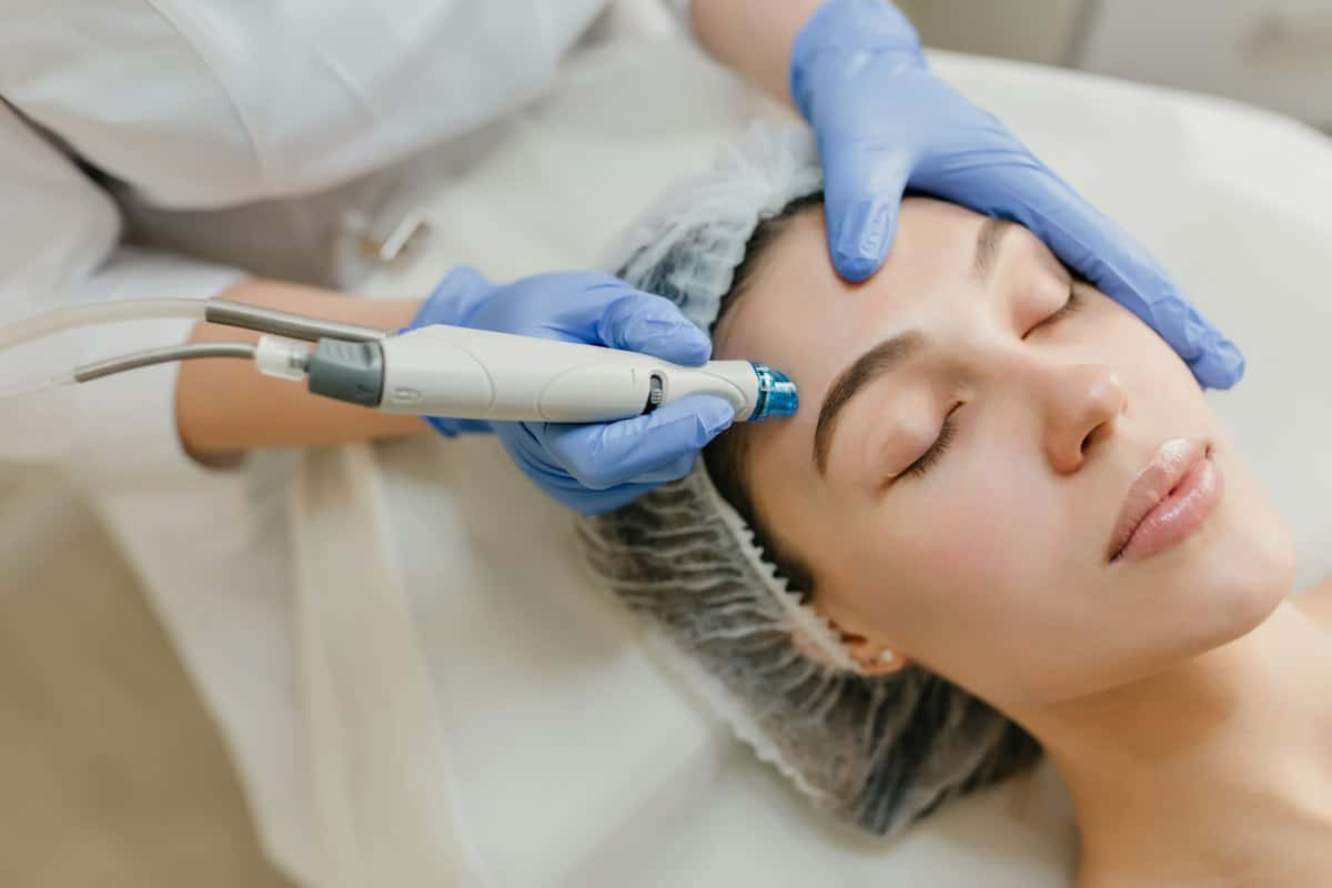 Clinician giving a facial treatment with a skin device
