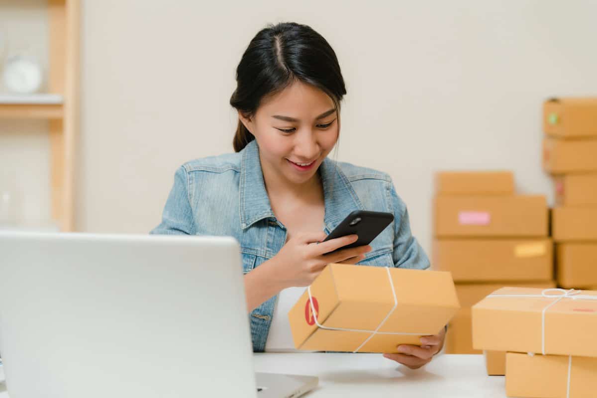Online store owner packing an order next to a laptop