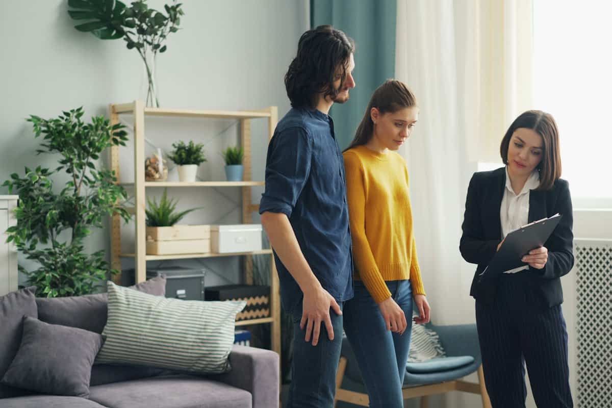 Real estate agent showing a home to a young couple