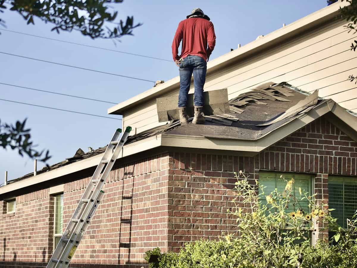 Roofer standing on a house roof during an inspection